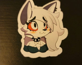 May include: A die-cut sticker featuring a cartoon wolf character with white fur, grey ears, and large orange eyes. The character wears a black spiked collar with a pentagram pendant and a dark teal top, displaying a soft, blushing expression.