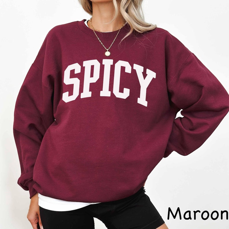 May include: A maroon sweatshirt with the word "SPICY" printed in white on the front.