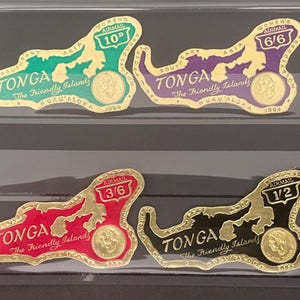 May include: Four die-cut postage stamps from Tonga, shaped like the island nation. Each stamp features a gold-coloured portrait, the text Tonga The Friendly Islands, and a specific denomination: 10d in green, 6/6 in purple, 3/6 in red, and 1/2 in black.