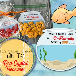 以下が含まれることがあります： 金魚が1匹入った黄色と青の金魚鉢。金魚鉢には「When I serve others I am O-Fish-ally Serving GOD Mosiah 2:11-18」という文字が書かれている。手前に「In the bag Gift Tag Red Crystal Treasures」と書かれたギフトタグがある。