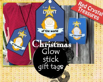 May include: Blue and yellow Christmas gift tags with a baby Jesus image and the text "I am the LIGHT of the world" and a scripture reference. The tags are attached to glow sticks.