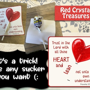 May include: A white card featuring a red heart-shaped lollipop and the text: Trust in the Lord with all thine HEART and lean not unto thine own understanding. Proverbs 3:5. A second image shows a Blow Pop lollipop inserted into a similar white card.