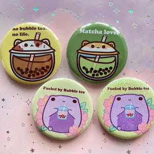 Puede incluir: Cuatro pines redondos con personajes de dibujos animados bebiendo té de burbujas. Los pines muestran el texto "no bubble tea. no life." "Matcha lover" "Fueled by Bubble tea" y "Fueled by Bubble tea".
