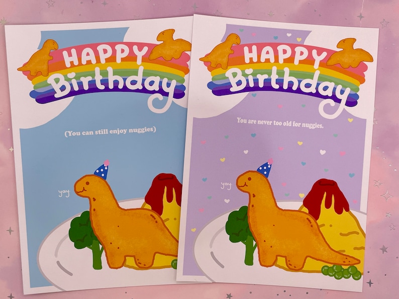 以下が含まれることがあります： パーティーハットをかぶった恐竜と虹が描かれた、カラフルな誕生日カード2枚。カードには「ハッピーバースデー」の文字と、「You can still enjoy nuggies」と「You are never too old for nuggies.」のフレーズが書かれています。