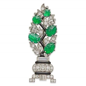 Puede incluir: Un broche de plata con base de esmalte negro y un diseño de árbol estilizado con piedras cabujón verde esmeralda y detalles de diamantes.