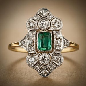 May include: An antique-style ring with a rectangular emerald center stone. The ring features a gold band and a decorative silver setting adorned with numerous small diamonds. The design is symmetrical and ornate, showcasing a vintage aesthetic.
