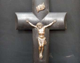 May include: A dark wood crucifix with a bronze Jesus figure. The crucifix has a small bronze scroll with the word "INRI" on it.