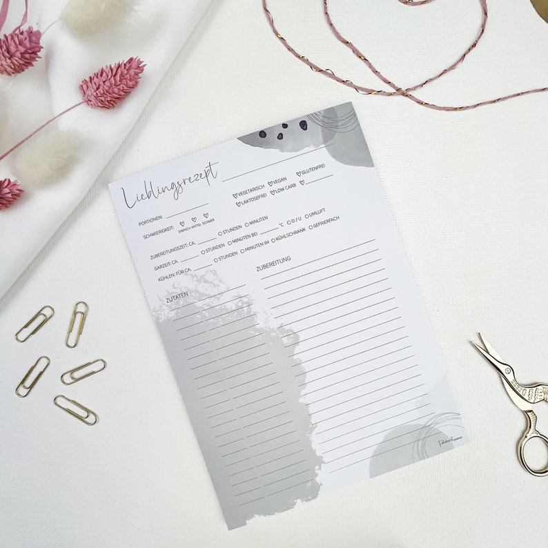 May include: A gray and white printable recipe card with the title "Lieblingsrezept" in German. The card has sections for portions, serving suggestions, cooking time, ingredients, and preparation instructions.