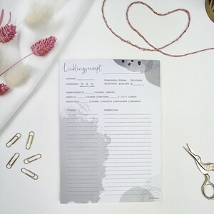 May include: A white recipe card with gray abstract watercolor designs. The card has sections for recipe name, servings, difficulty, preparation time, cook time, cool time, ingredients, and instructions. The card also has checkboxes for vegetarian, vegan, gluten-free, lactose-free, and low-carb.