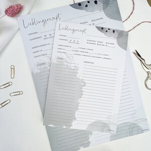 May include: Two gray printable recipe cards with a gray watercolor background. The cards have headings for "Lieblingsrezept" (German for "favorite recipe"), "Portionen" (portions), "Schwierigkeit" (difficulty), "Zubereitungzeit" (preparation time), "Garzeit" (cooking time), "K&uuml;hlen f&uuml;r" (cool for), and "Zutaten" (ingredients).