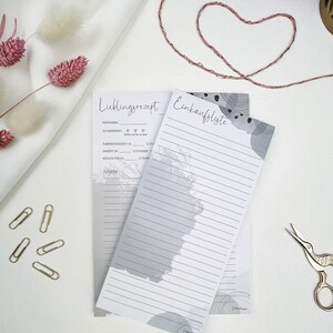 May include: Two white recipe cards with gray watercolor accents. The top card has the title "Lieblingsrezept" and the bottom card has the title "Einkaufsliste".