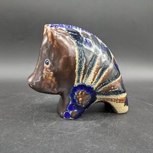 May include: A ceramic figurine of a brown and blue boar with intricate details. The boar has a stylised design with blue and white accents.