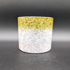 Könnte beinhalten: Ein Keramik-Pflanztopf mit gesprenkeltem Überzug. Die obere Hälfte des Topfes ist hellgrün, die untere Hälfte hellrosa.