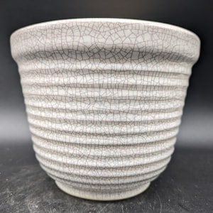 May include: White ceramic planter with a crackled glaze and a ribbed design.