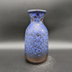 以下が含まれることがあります： 斑点のある釉薬をかけた青と茶色の陶器の花瓶。花瓶は首が細く、底が広い。