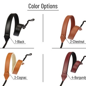 Puede incluir: Imagen que muestra cuatro opciones de color para una correa de c&aacute;mara. Las opciones son negro, casta&ntilde;o, co&ntilde;ac y burdeos. El texto "Color Options" est&aacute; en la parte superior. Cada correa de cuero tiene un cord&oacute;n negro para sujetar.