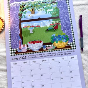 Könnte beinhalten: Ein Wandkalender für Juni 2027 mit violettem Rand und einer Fensterillustration, die einen Garten mit Rasenmäher, Vogelhaus und Erdbeeren zeigt. Der Text lautet: Strawberries from the garden today. Sunlight slid across the windowsill, and lawn mowers whirled from yard to yard.