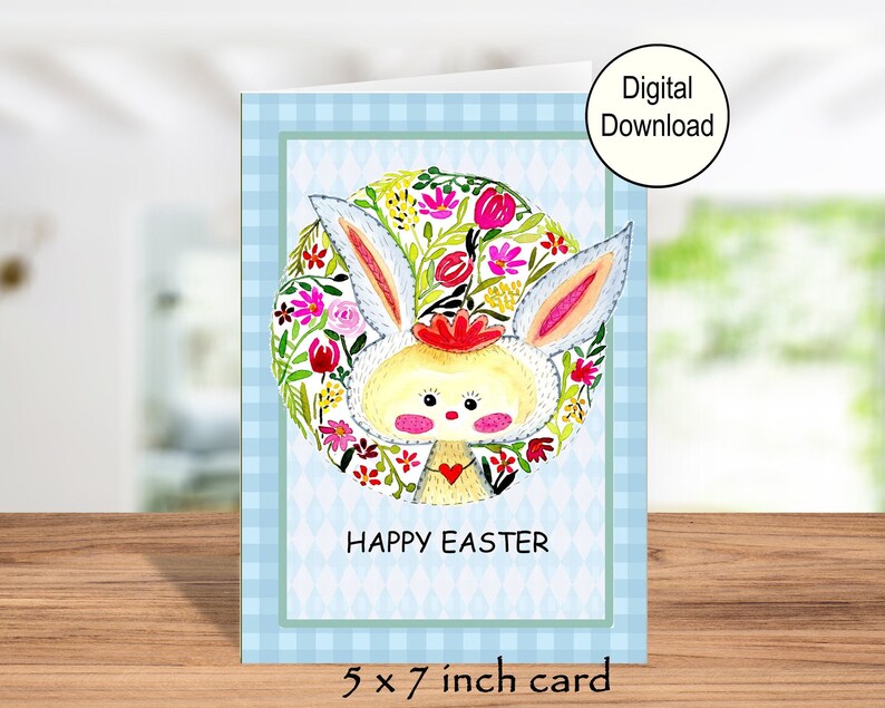 A printable greeting card with an adorable hand-painted bunny on the inside. The message says Happy Easter.  The card has a blue checked. This pic shows the card on a shelf.