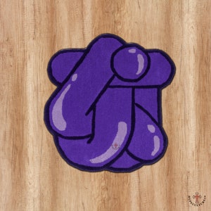 May include: A purple rug with a unique abstract design of overlapping shapes. The rug is made of soft, plush material and has a modern, contemporary style.
