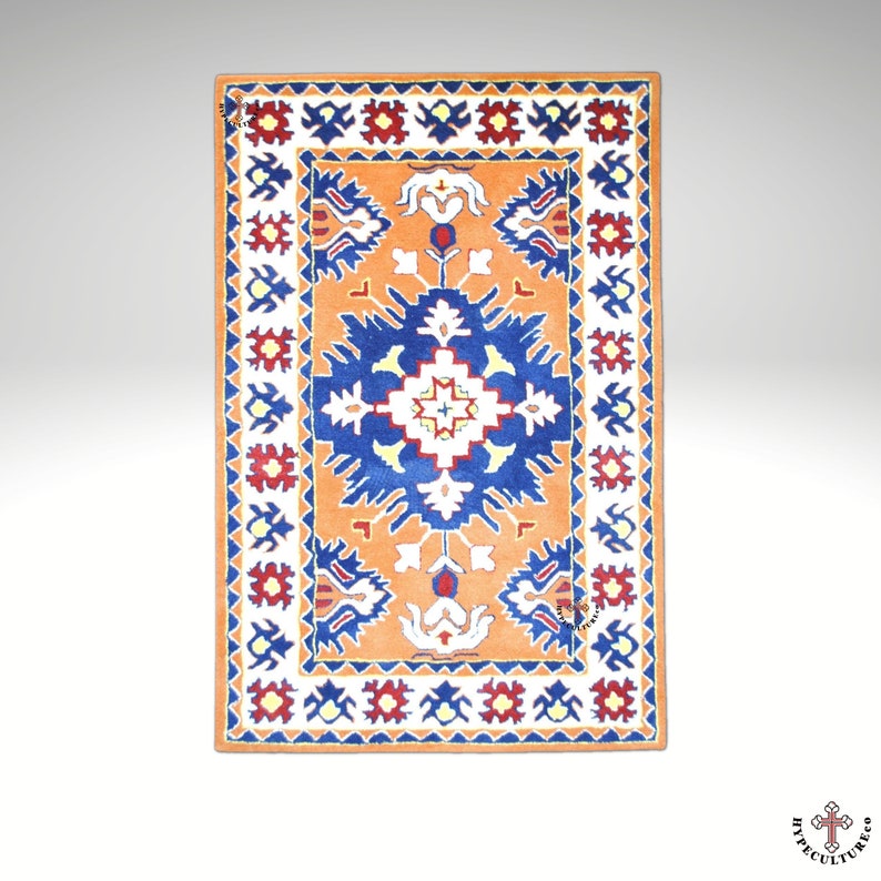 May include: A traditional rug with a geometric pattern in shades of blue, red, white, and orange. The rug has a central medallion with a starburst design and a border with repeating floral motifs.