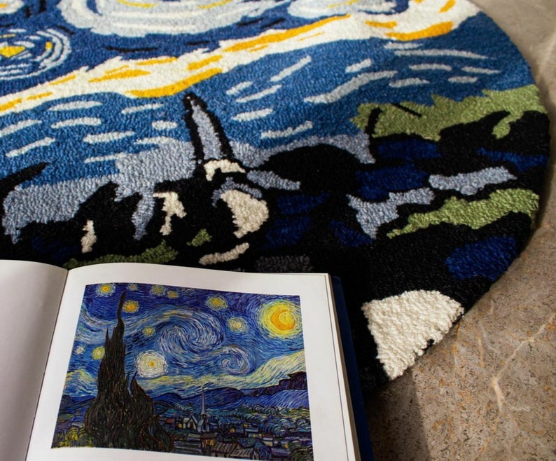 May include: A close-up of a blue and white rug with a swirling pattern, resembling Vincent van Gogh's "Starry Night". The rug is made of soft, plush fibers and has a round shape.