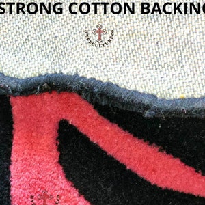 May include: Close-up of a black and red rug with a cotton backing. The rug has a geometric pattern and the text "HYPECULTURECO" is visible in the bottom right corner.