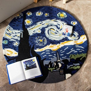 May include: A round rug with a blue and yellow design depicting Vincent van Gogh's "Starry Night" painting. The rug is made of a soft, plush material and features a swirling sky with stars and a church.