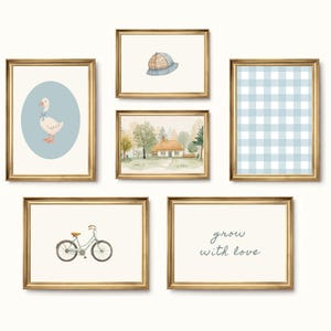 May include: Six framed art prints with gold frames. The prints feature watercolour illustrations of a goose, a hat, a house, a bicycle, a blue gingham pattern, and the text "grow with love."