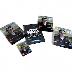 Könnte beinhalten: Eine Sammlung von Star Wars Unlimited Sammelkarten und ein kleines Heft. Die Karten zeigen einen Mann im Anzug und Sonnenbrille, mit dem Wort "SPY" und anderem Spieltext. Das Heft zeigt das Star Wars Unlimited Logo.