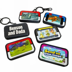 May include: A collection of rectangular keychains with various images and text. One keychain reads "Benson and Dada." Other keychains feature colorful designs and the text "Send us your image!"
