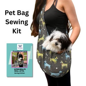 May include: A sewing kit for a reversible pet carrier featuring a grey fabric with a repeating pattern of yellow and blue dogs. The kit includes a pattern labeled 'Reversible Pet Carrier' and 'INTERMEDIATE SKILL LEVEL' with a photo of the finished bag.