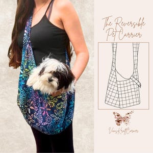 May include: Reversible pet carrier with a colorful floral pattern in blue, purple, and yellow. The carrier is being worn, holding a small dog with black and white fur. The text "The Reversible Pet Carrier" is visible.