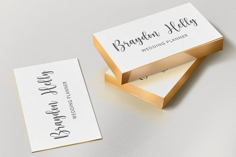 May include: White business cards with gold edges, featuring the name "Braydon Helly" and the title "Wedding Planner" in elegant script. One card is separate, while others are stacked.