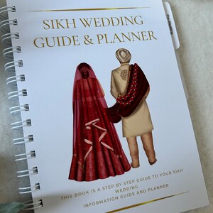 May include: A white spiral bound book with a gold title "Sikh Wedding Guide & Planner". The cover features an illustration of a bride and groom in traditional Sikh wedding attire. The text "This book is a step by step guide to your Sikh wedding information guide and planner" is printed in gold at the bottom of the cover.