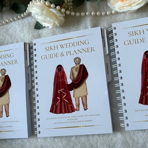 May include: Three white spiral bound notebooks with gold accents. Each notebook has a cover image of a Sikh couple in traditional wedding attire. The text on the cover reads "Sikh Wedding Guide & Planner".