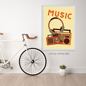 May include: A yellow poster with the word "MUSIC" in orange text. An orange and brown retro boombox with headphones is pictured below the text. The poster has the text "LITTLE LOVES INK" at the bottom.