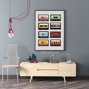 Puede incluir: Una impresi&oacute;n enmarcada de un dise&ntilde;o de cinta de casete vintage con una variedad de colores y patrones. La impresi&oacute;n se titula "Little Loves Ink".