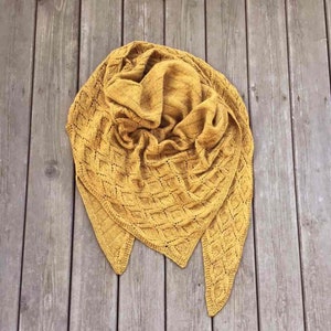 May include: A mustard yellow knitted shawl with a diamond pattern.