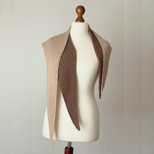 May include: A triangular knitted scarf with a beige and brown colour gradient. The scarf is displayed on a white mannequin.
