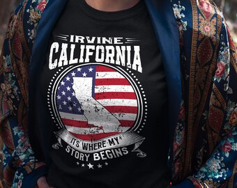 May include: Black t-shirt with a white graphic design featuring the text "Irvine California" and a stylized American flag with the outline of California. The text below the flag reads "It's where my story begins".