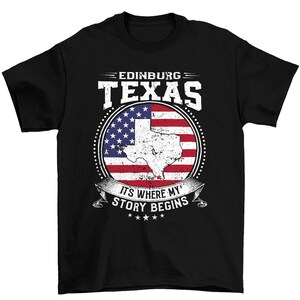 May include: Black t-shirt with a distressed American flag design and the text "EDINBURG TEXAS ITS WHERE MY STORY BEGINS".