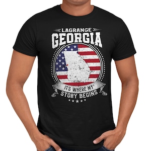 May include: Black t-shirt with a distressed white graphic of the state of Georgia with an American flag overlay. The text "Lagrange Georgia" and "It's Where My Story Begins" is printed on the shirt.