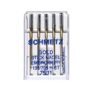Könnte beinhalten: Eine Packung mit fünf goldenen Sticknadeln aus Titan-Nitrid in einem durchsichtigen Kunststoffbehälter. Die Nadeln haben die Größe 75/11, 130/705 H-ET und sind mit "SCHMETZ GOLD STICK-NADEL EMBROIDERY" beschriftet.