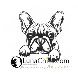 May include: Black and white illustration of a French Bulldog peeking over a white surface. The dog's paws are visible and the text "LunaChi.com" is below the dog. The text "Handmade in Germany" is below the website address.