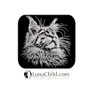 Puede incluir: Imagen bordada de la cara de un gato Maine Coon sobre un cuadrado negro. El gato está representado en hilo blanco, mirando hacia arriba con detalles de pelaje y rasgos. El logotipo de LunaChild.com está en la parte inferior.