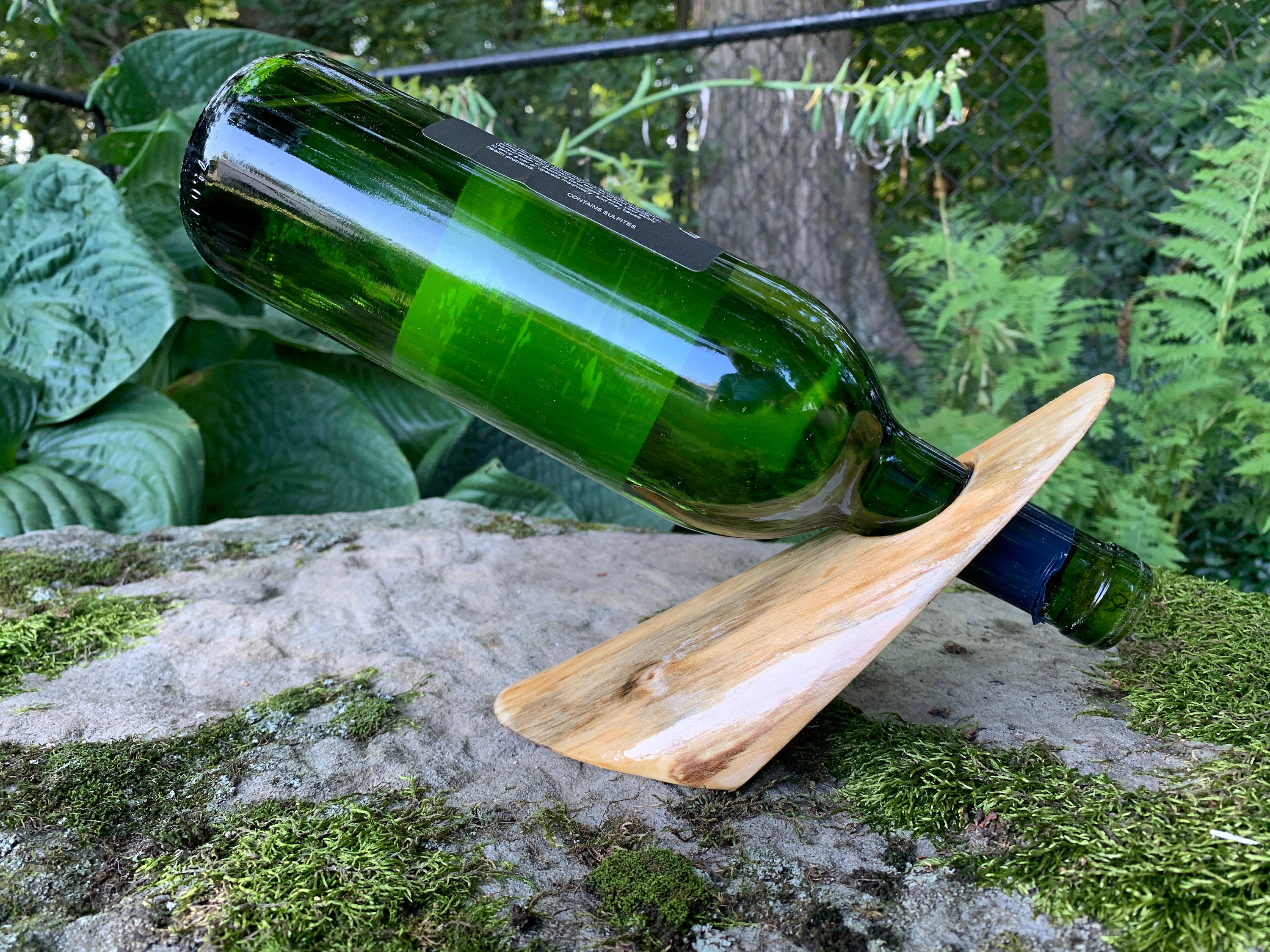 porte-bouteille de vin unique, fabriqué à partir d'une bûche solide et naturelle. l'écorce a été soigneusement enlevée pour montrer le grain