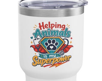May include: A white stainless steel tumbler with a lid featuring a graphic of a paw print inside a superhero shield, a red cape, and a stethoscope. The text reads Helping Animals is my Superpower in red, blue, and yellow lettering.