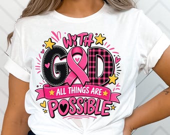 May include: A white short-sleeved t-shirt featuring a graphic design with the text "WITH GOD ALL THINGS ARE POSSIBLE". The design includes a pink awareness ribbon, black and pink plaid lettering, yellow stars, and small pink hearts.