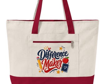 May include: A cream-colored canvas tote bag with dark red handles and a matching red base. The front features a zippered pocket with a graphic print that reads "Difference Maker" in blue and red text, accompanied by a pencil, an apple, and a notebook.
