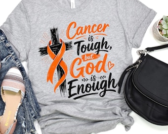 May include: A heather gray t-shirt featuring a black cross with an orange awareness ribbon and the text Cancer is Tough but God is Enough. The shirt is displayed with blue denim jeans, patterned flat shoes, and a black crossbody bag.